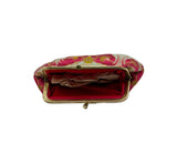 A small, rounded coin purse made of pink brocade fabric with gold and silver floral patterns, featuring a gold-tone metal clasp frame, 