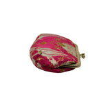 A small, rounded coin purse made of pink brocade fabric with gold and silver floral patterns, featuring a gold-tone metal clasp frame, 
