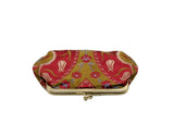 A small fabric coin purse with a red and gold floral pattern, featuring a gold metal frame and clasp closure, 