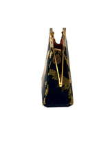 A small coin purse made of Hatice black and gold fabric circular patterns, featuring a gold metal clasp closure, 