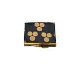 A small coin purse made of Hatice black and gold fabric circular patterns, featuring a gold metal clasp closure, 