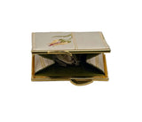 An open vintage clutch purse with a gold-tone metal frame and handle, featuring a cream satin cover with embroidered floral details on the top flap and a dark green interior lining.